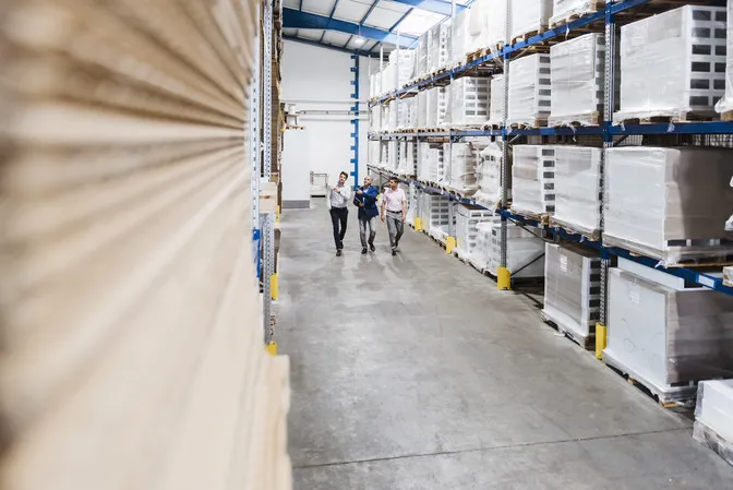 Business professionals discussing logistics inside a warehouse.
